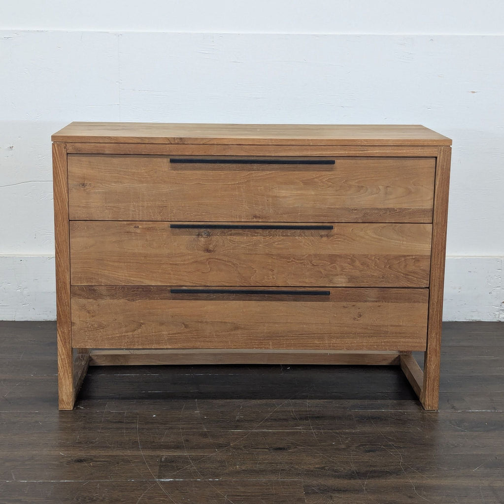 2. Front view of a Crate and Barrel dresser in natural wood, featuring three drawers with long black handles.