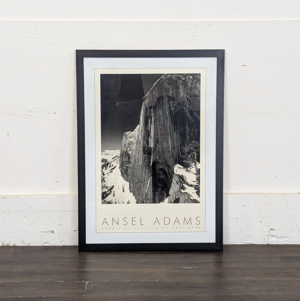 1. Framed black-and-white Ansel Adams print titled "Monolith, The Face of Half Dome" leaning against a wall.