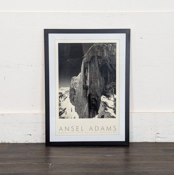 1. Framed black-and-white Ansel Adams print titled "Monolith, The Face of Half Dome" leaning against a wall.