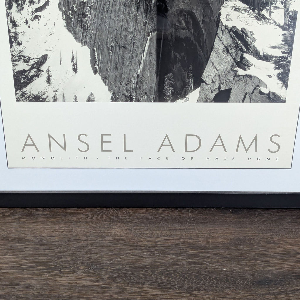 3. Close-up of the bottom of a framed Ansel Adams print, highlighting the text and snowy mountain image.