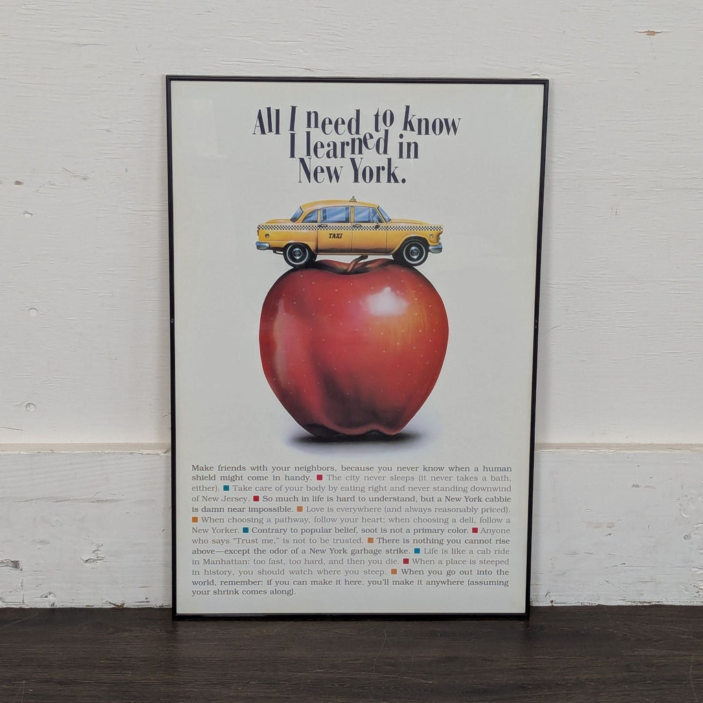 2. Poster print with a yellow taxi atop a large apple and New York-themed text in a simple black frame.