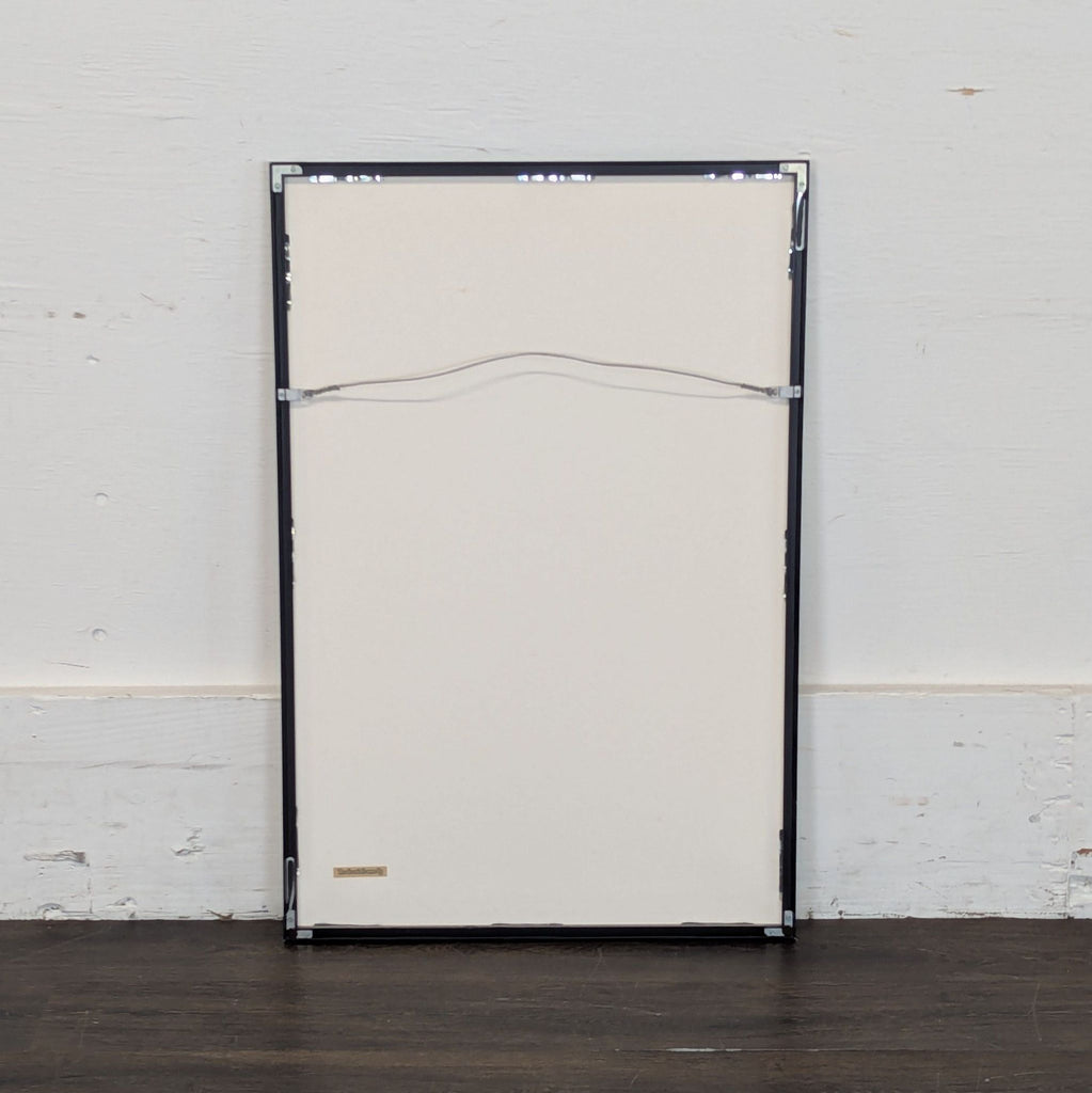 3. Back view of a framed print, showing hanging wire and corners, suitable for wall mounting.