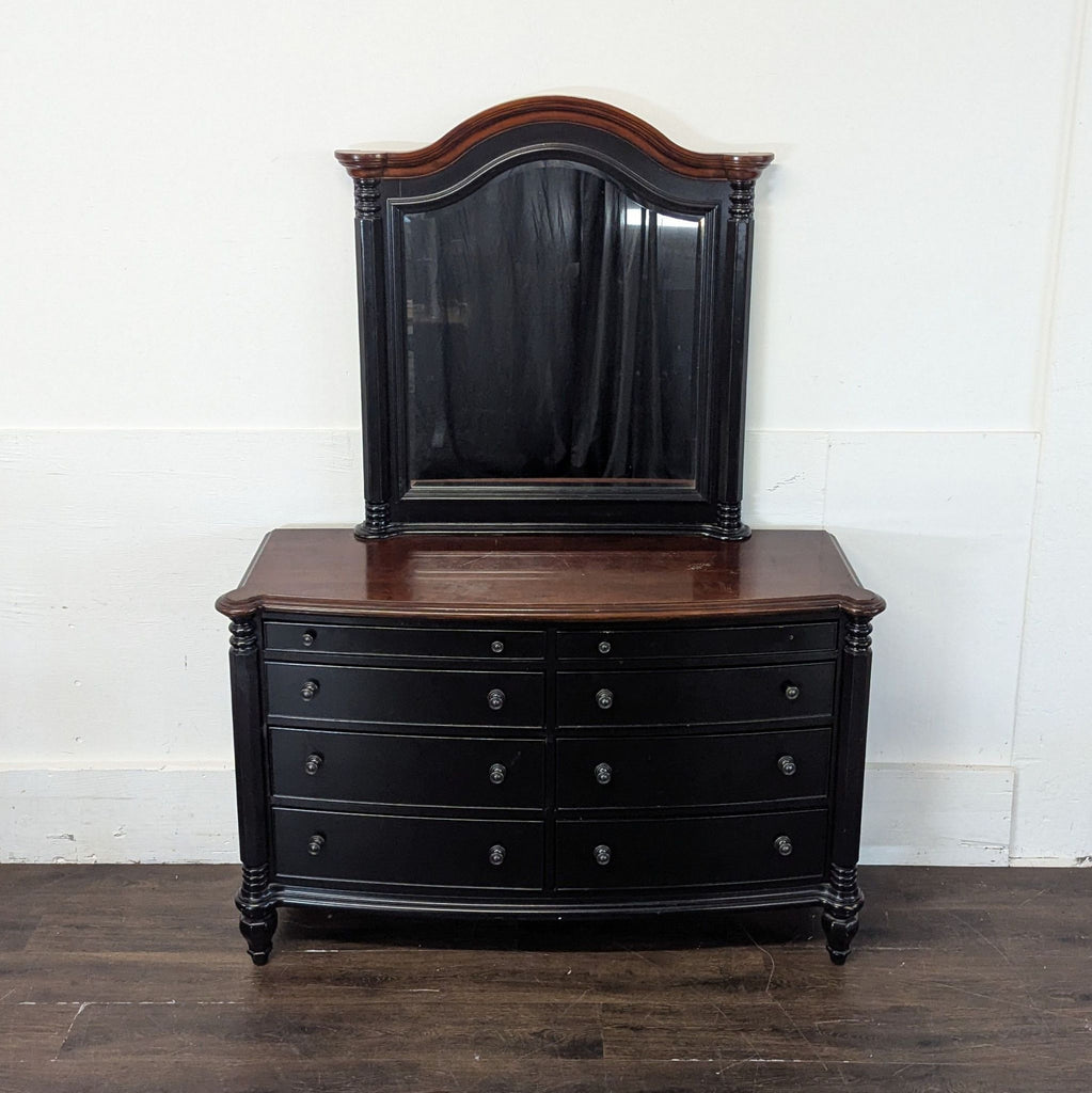 3. Classic dresser in black with a matching framed mirror, curved front, and contrasting brown wood top.