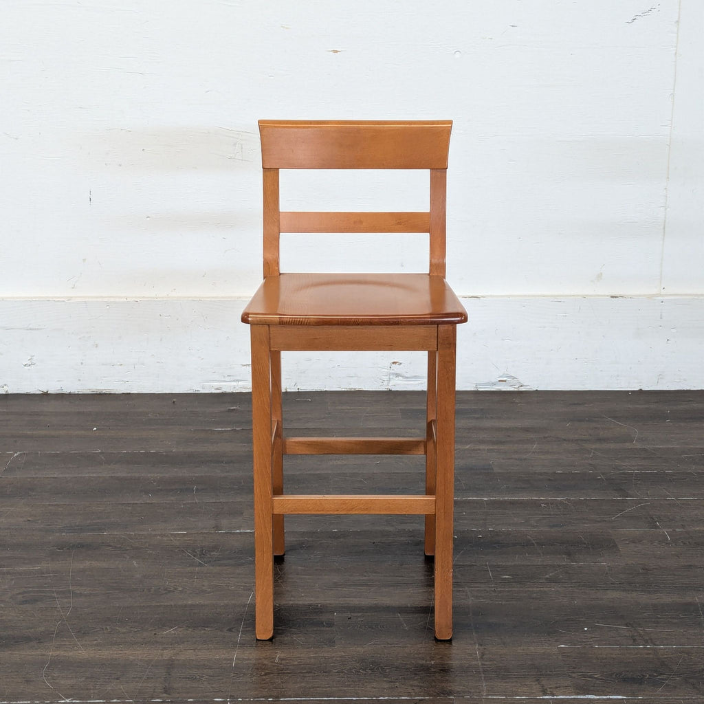 1. Wooden counter-height stool with a simple slatted backrest and square seat, placed on a dark floor.  
