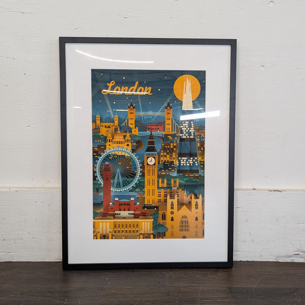 1. Framed illustrated print of London landmarks with bold colors, viewed propped against a white wall.
