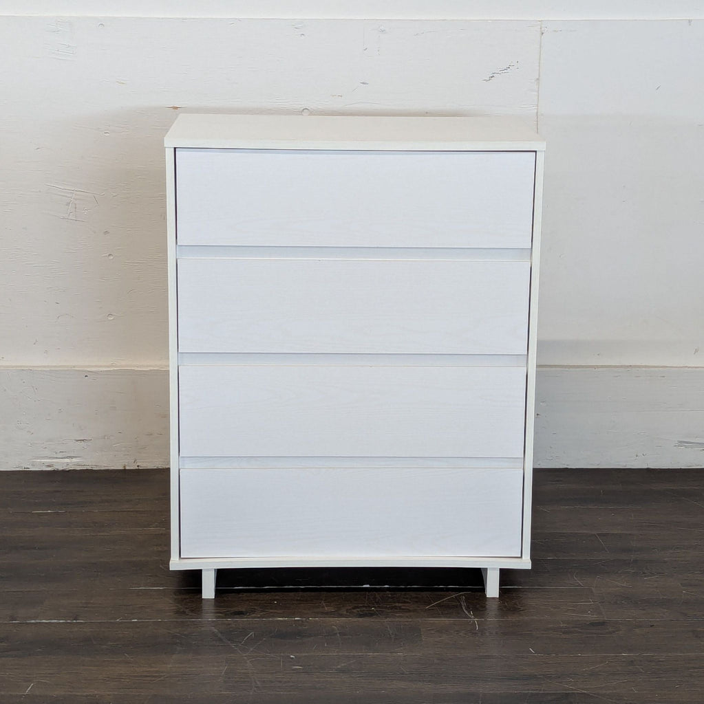 2. Minimalist Target dresser with four drawers, finished in white, displayed on a dark wood floor.