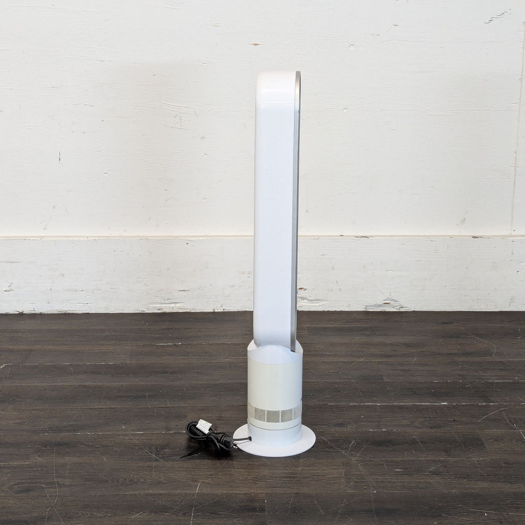 2. Side view of a white Dyson bladeless fan with power cord, displayed on a dark wooden floor.