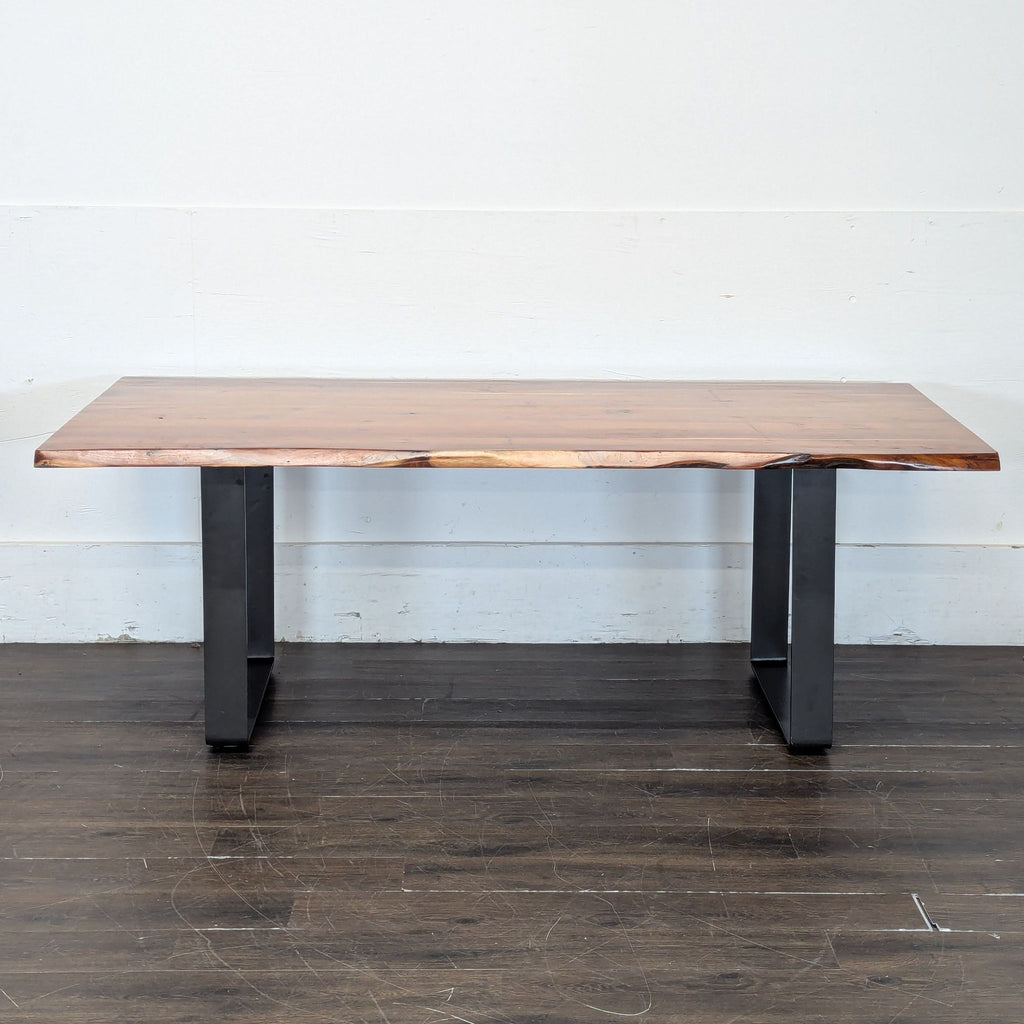 2. Rectangular wooden dining table with live edge detail and black metal legs, placed on a dark wood floor.