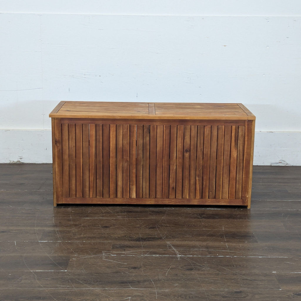 1. Rectangular wooden trunk with slatted panels, closed and placed on a dark wooden floor.