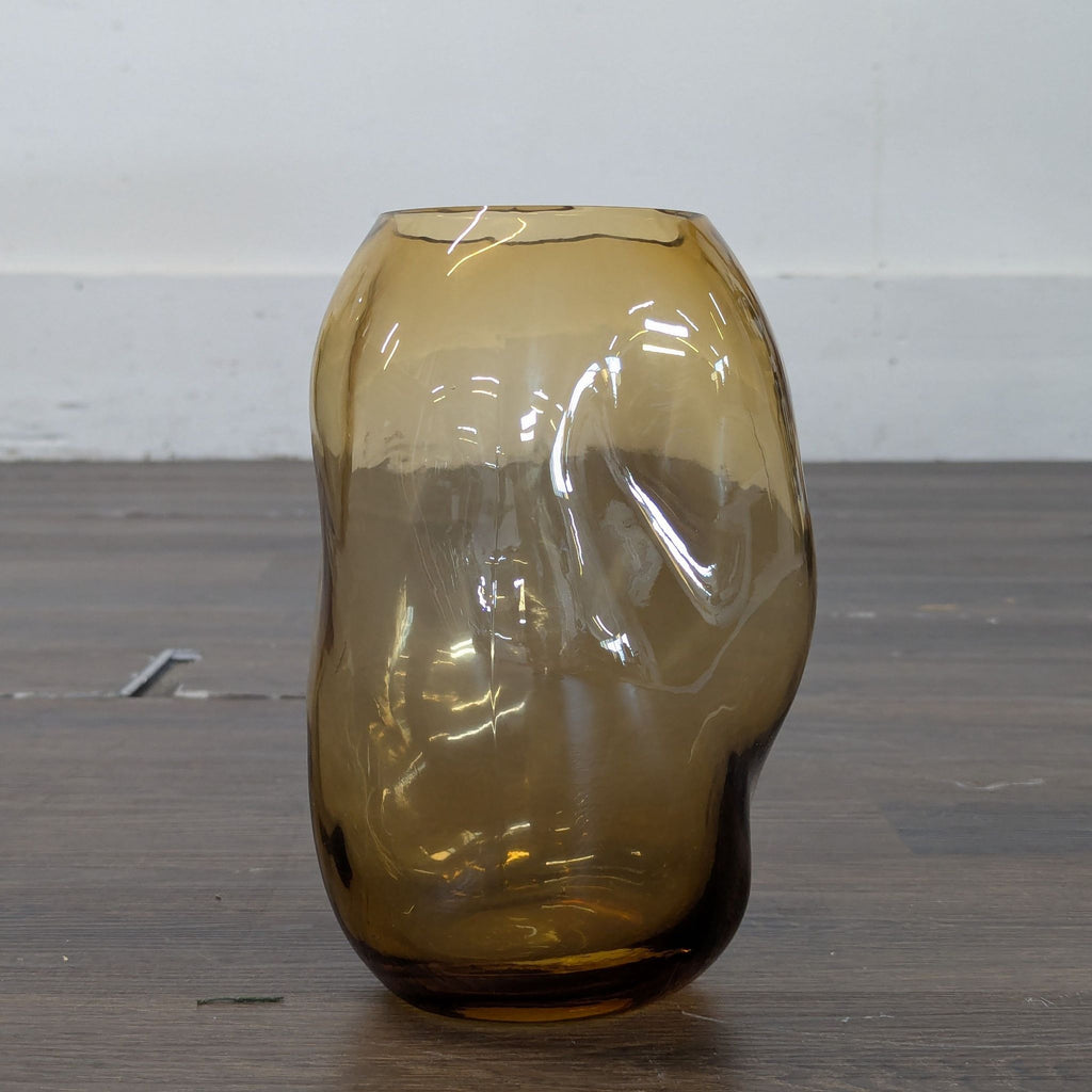 2. Amber-tinted, asymmetrical glass vase featuring organic, wavy contours and a reflective surface.