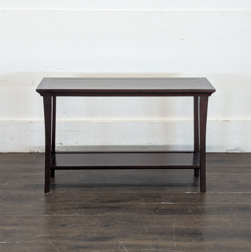 1. Dark wood console table with a lower shelf, clean lines, and tapered legs against a white wall.  