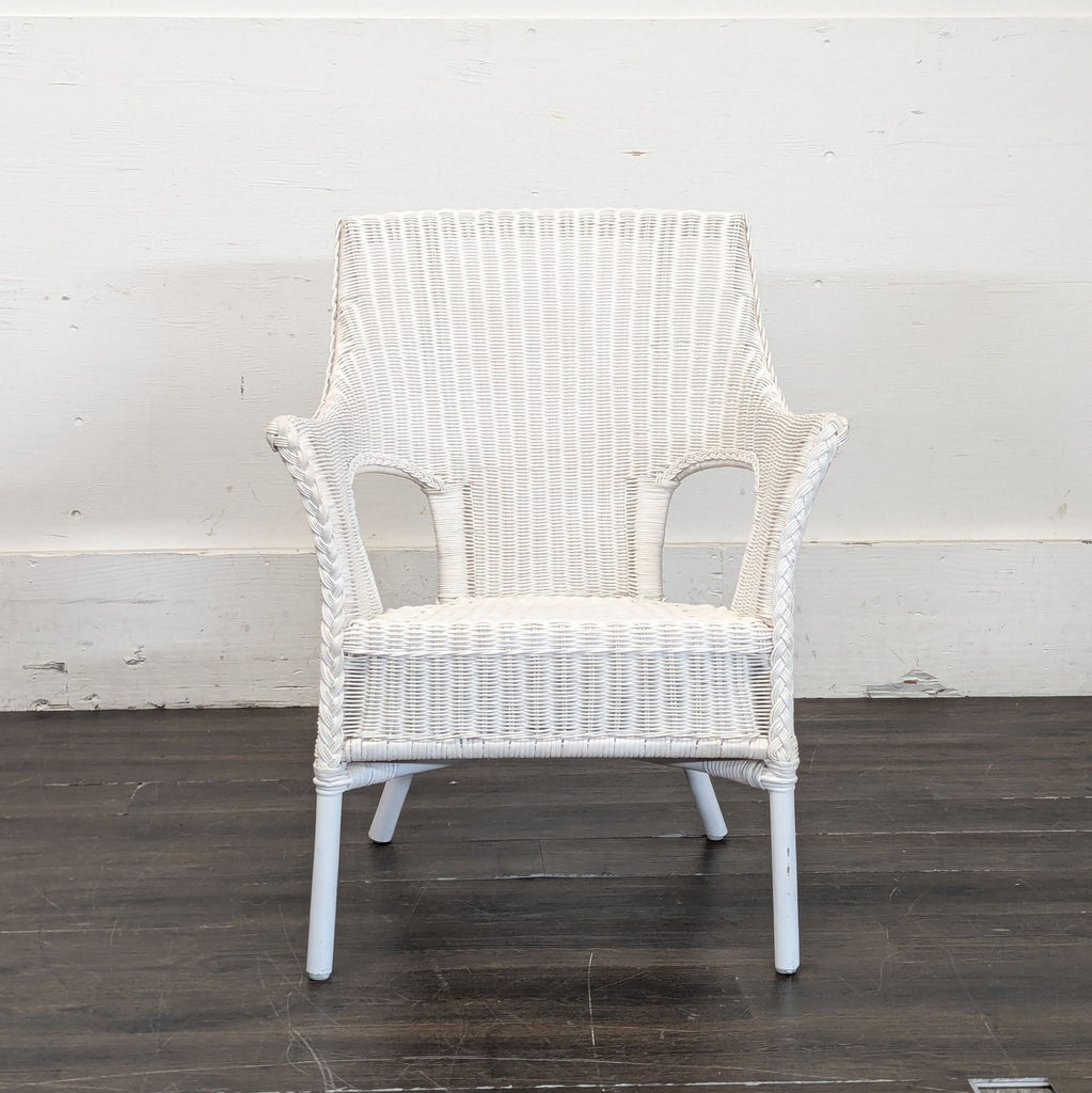 3. Plain white wicker lounge chair with open armrests and no cushion, placed on a dark wooden floor.