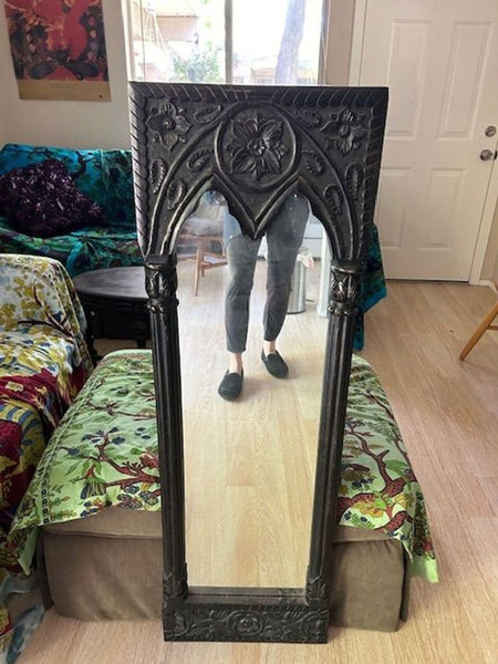 a large gothic style mirror with a gothic design.