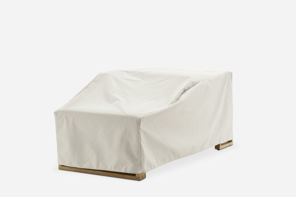 a white canvas cover over a beige fabric sofa.