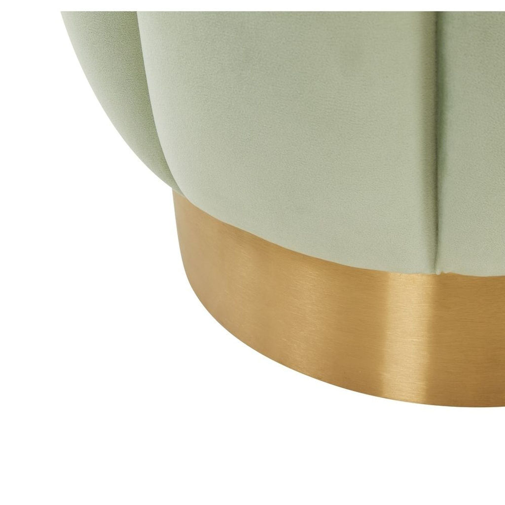 2. Close-up view of the Reperch ottoman’s brushed gold base with pale green velvet upholstery above it.