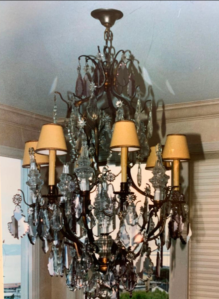 2. Elegant lighting fixture featuring intricate glass crystals and gold accents, suspended in a sunlit room.