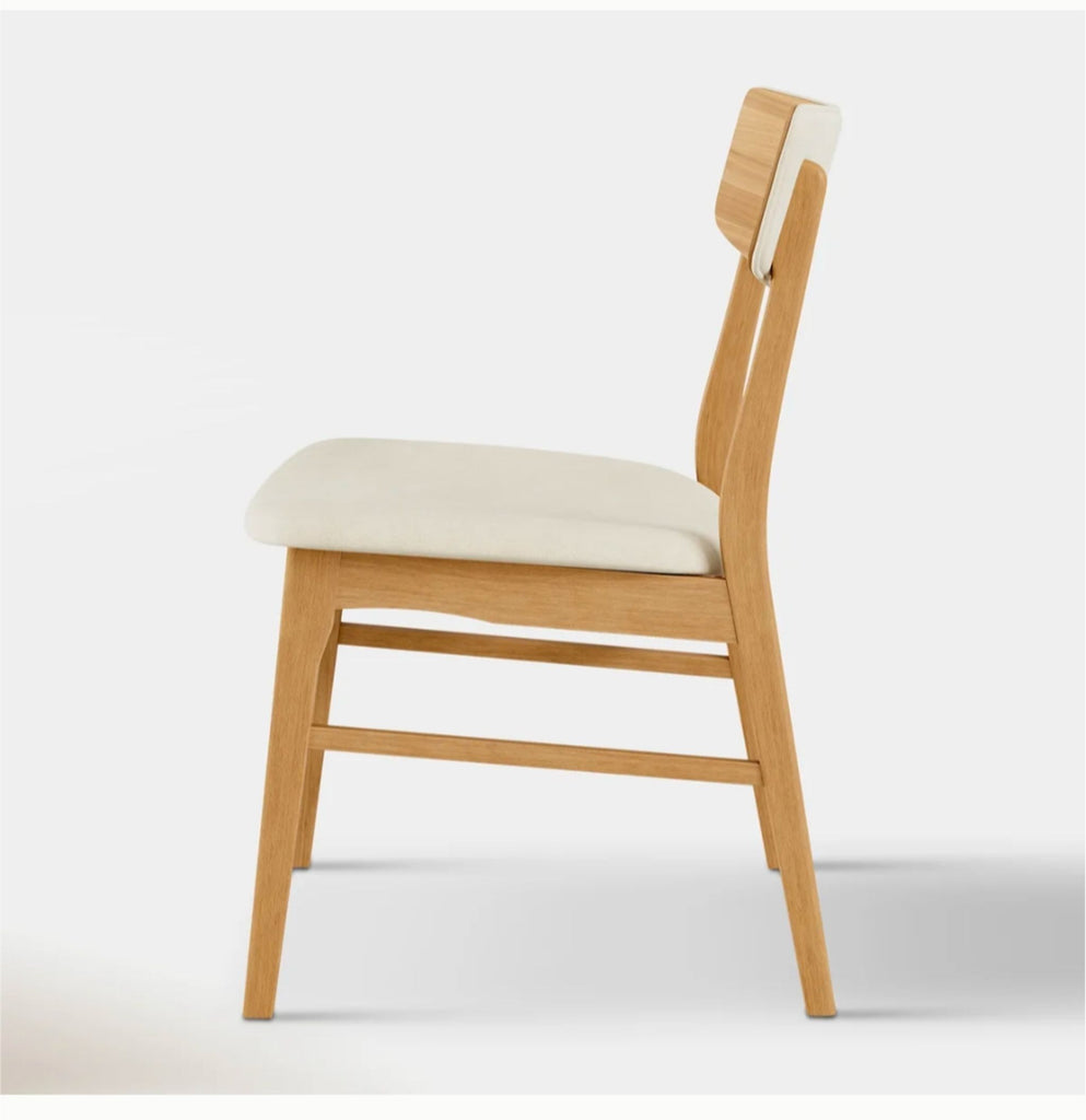 1. Modern dining chair with upholstered seat and wooden legs, positioned at a dining table.