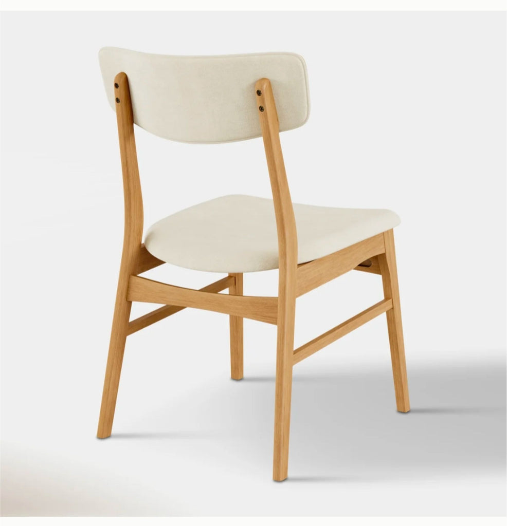 2. Sleek, minimalist dining chair featuring a high back and metal frame, set on a hardwood floor.