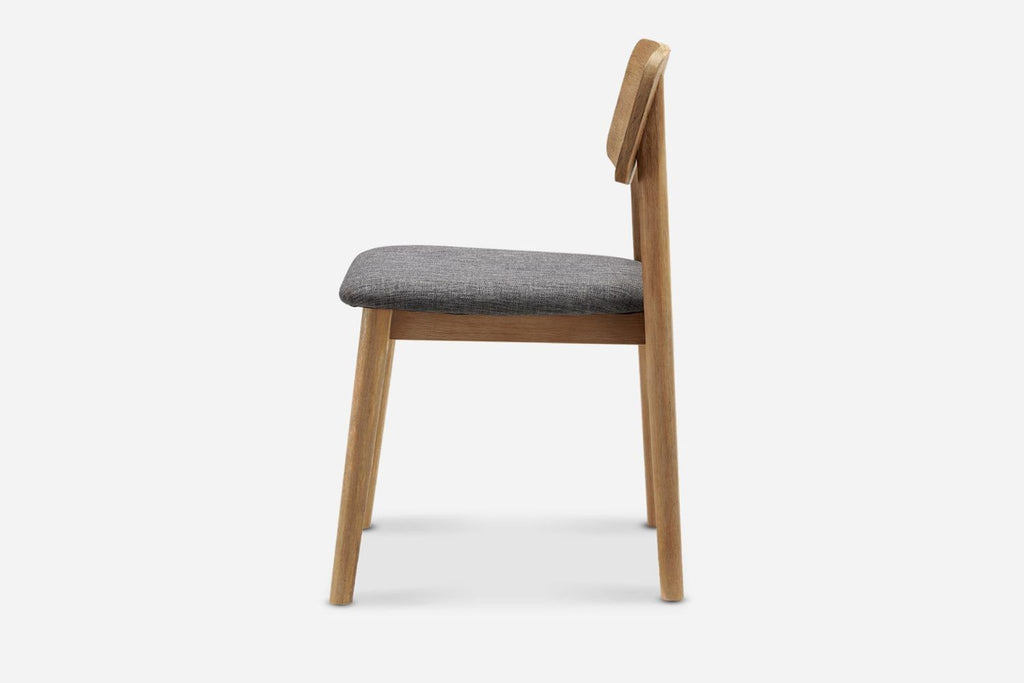 3. Side profile of Reperch dining chair displaying its wooden frame and padded gray seat.