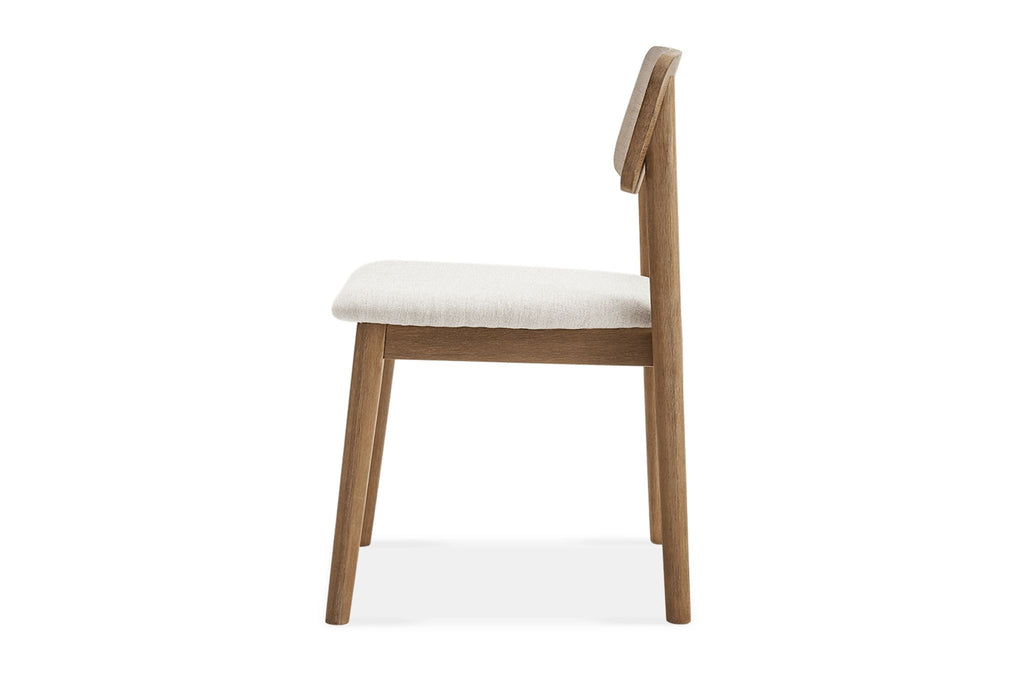 Side profile of Reperch dining chair featuring natural wood frame and plush cream cushion for dining spaces.