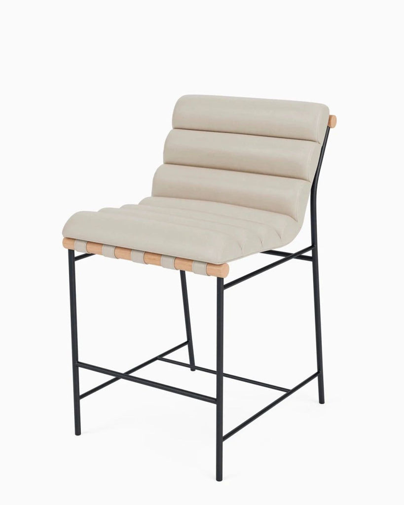 2. Angled side view of a contemporary stool featuring a ribbed beige cushion and sleek black metal legs.
