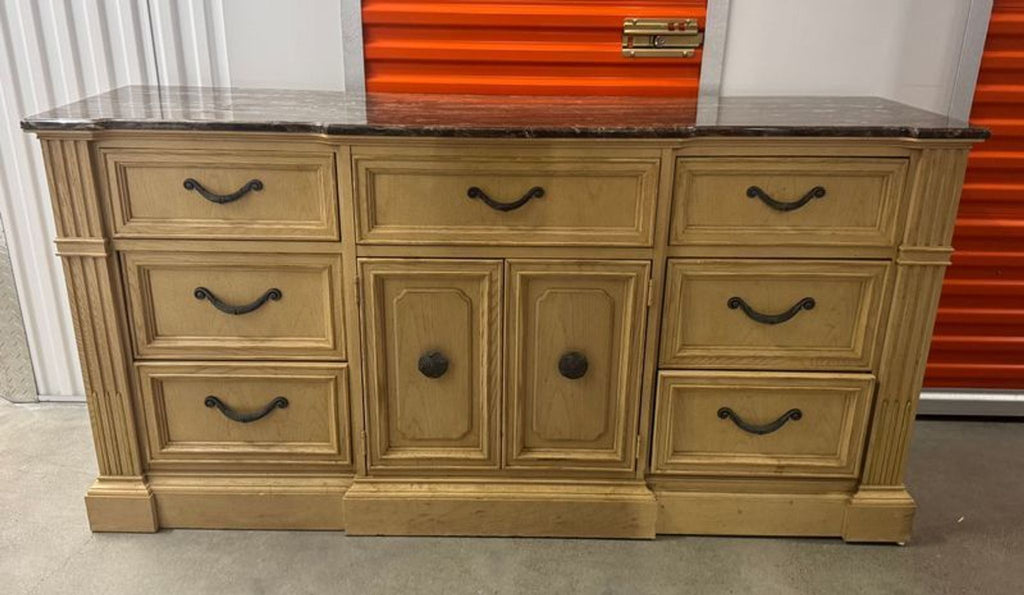 1. Stanley Furniture dresser with a marble top, nine drawers, and central doors, in light wood finish.