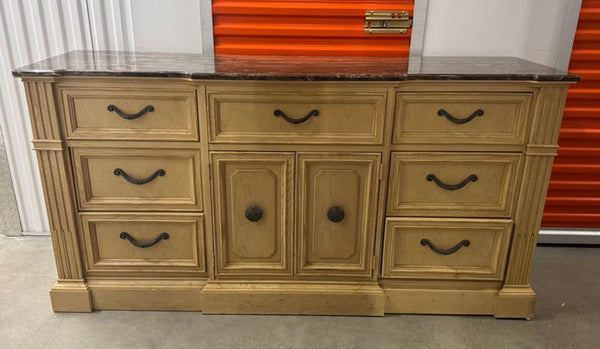 1. Stanley Furniture dresser with a marble top, nine drawers, and central doors, in light wood finish.