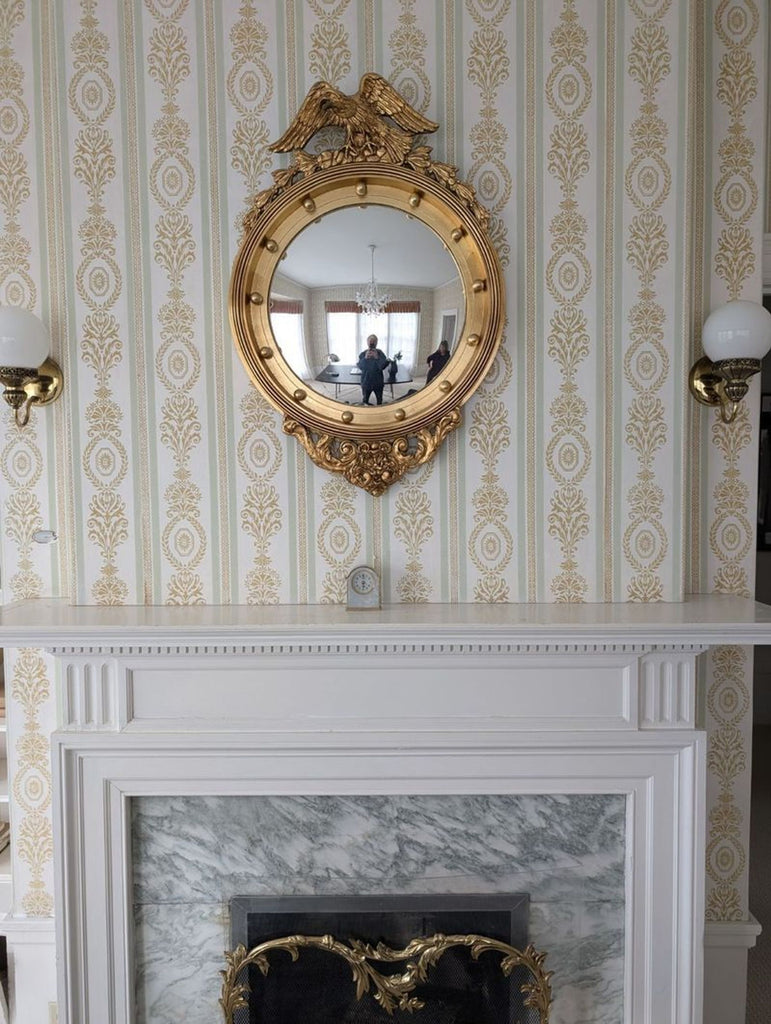 a mirror on the wall above a fireplace.