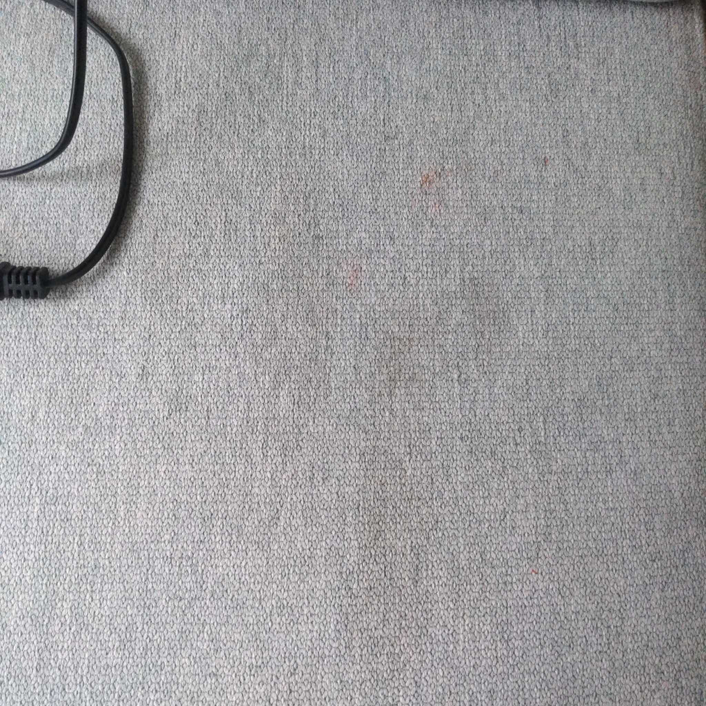 3. Close-up of textured light gray sectional fabric showing minor spots and a visible black cord.