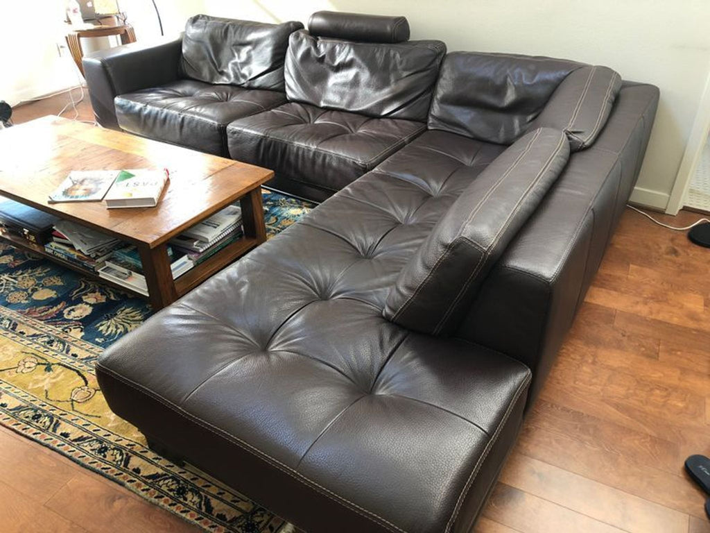 Brown leather Cierre Imbottiti sectional with tufted seats and wide armrests in L-shaped design.