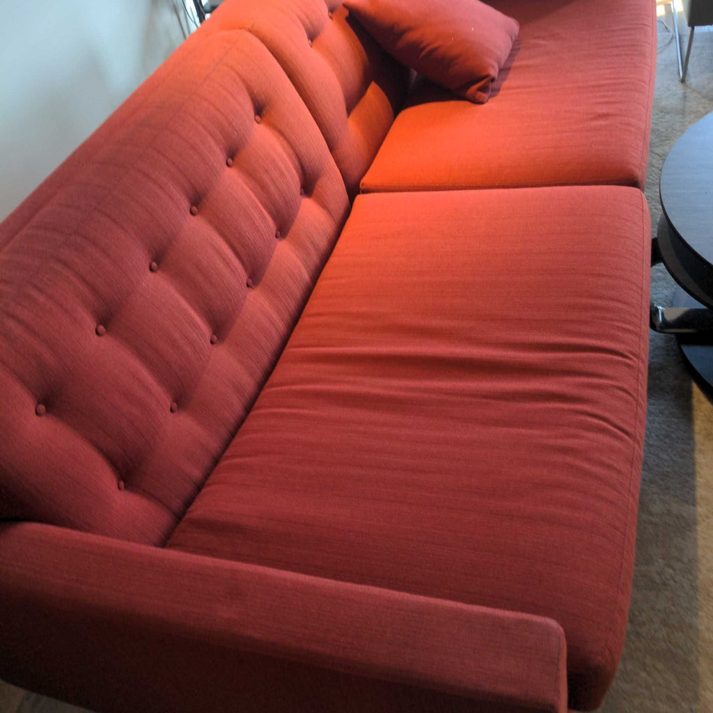 2. Close-up side view of a red Room & Board 3-seat sofa with tufted back and a matching cushion.