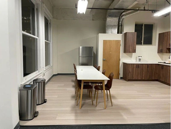 1. Rectangular dining table with light wood legs and a white top, surrounded by brown chairs in a modern kitchen.