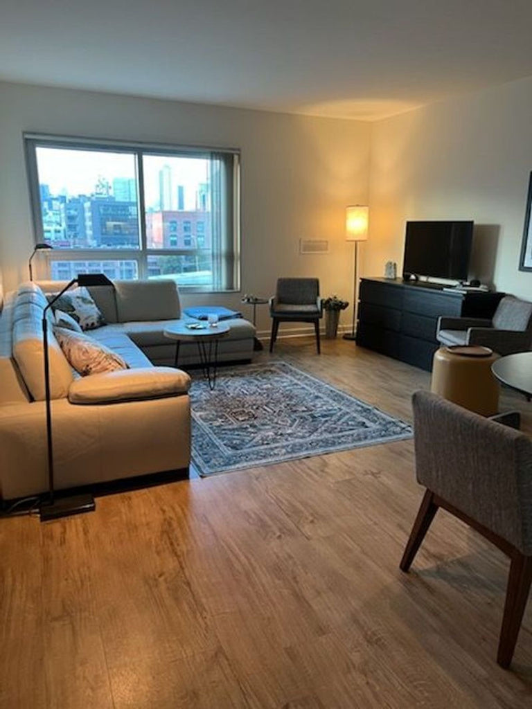 1. Modern living room with a Reperch sectional sofa, large window, TV stand, and wooden floors.