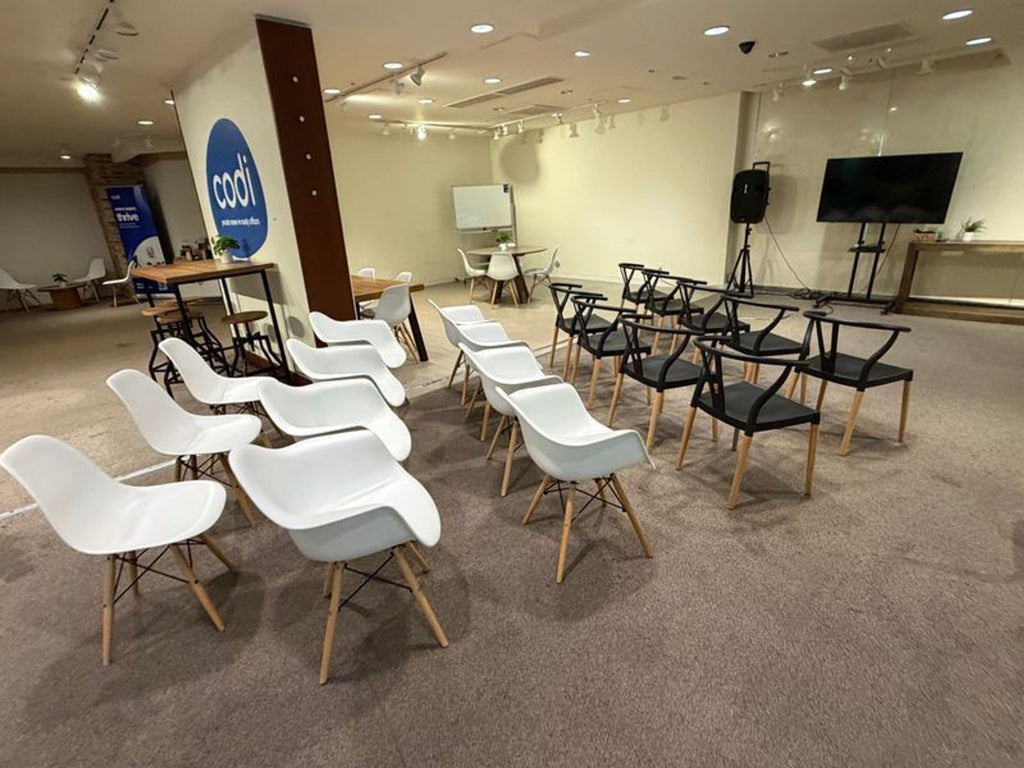 3. Black and white dining chairs neatly organized in a bright, open space prepared for a group event.