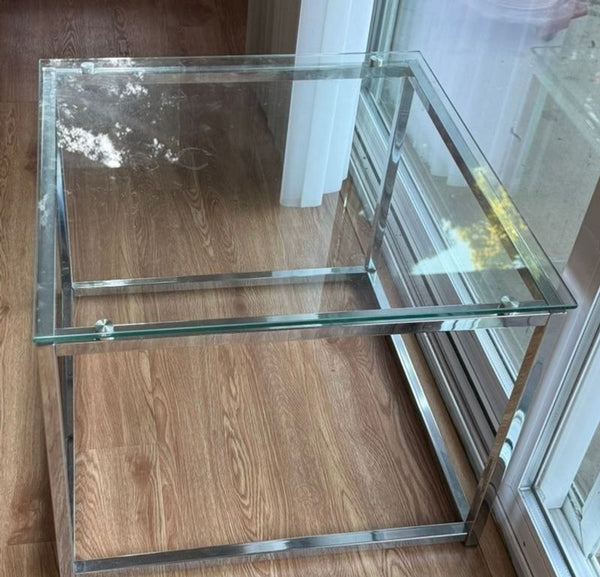 1. Square glass end table with chrome metal frame placed on wood floor by a window.