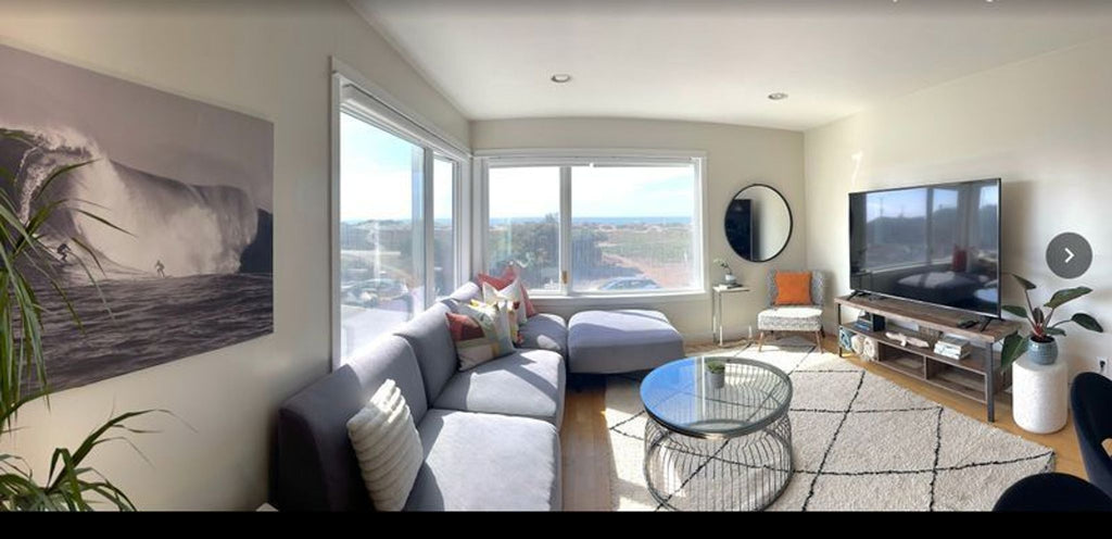 1. Modern living room featuring a light Reperch sectional sofa, large windows, and a beach-themed decor.