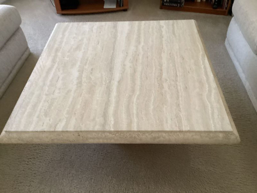 a large square coffee table with a white marble top.