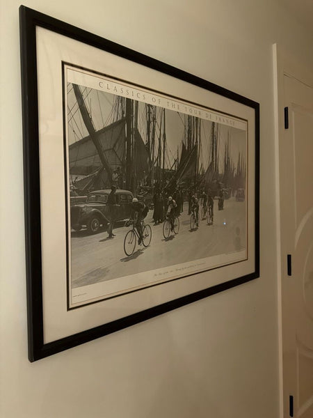 1. Framed "Classics of the Tour de France" black-and-white print by Reperch, hanging on a wall.