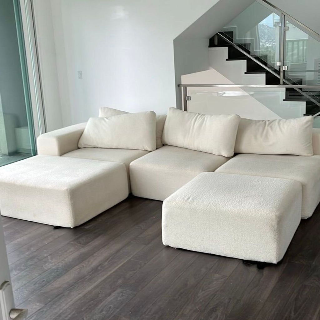 Modern Diorama sectional sofa in soft cream fabric, includes two ottomans for lounging or extra seating, fits various spaces.