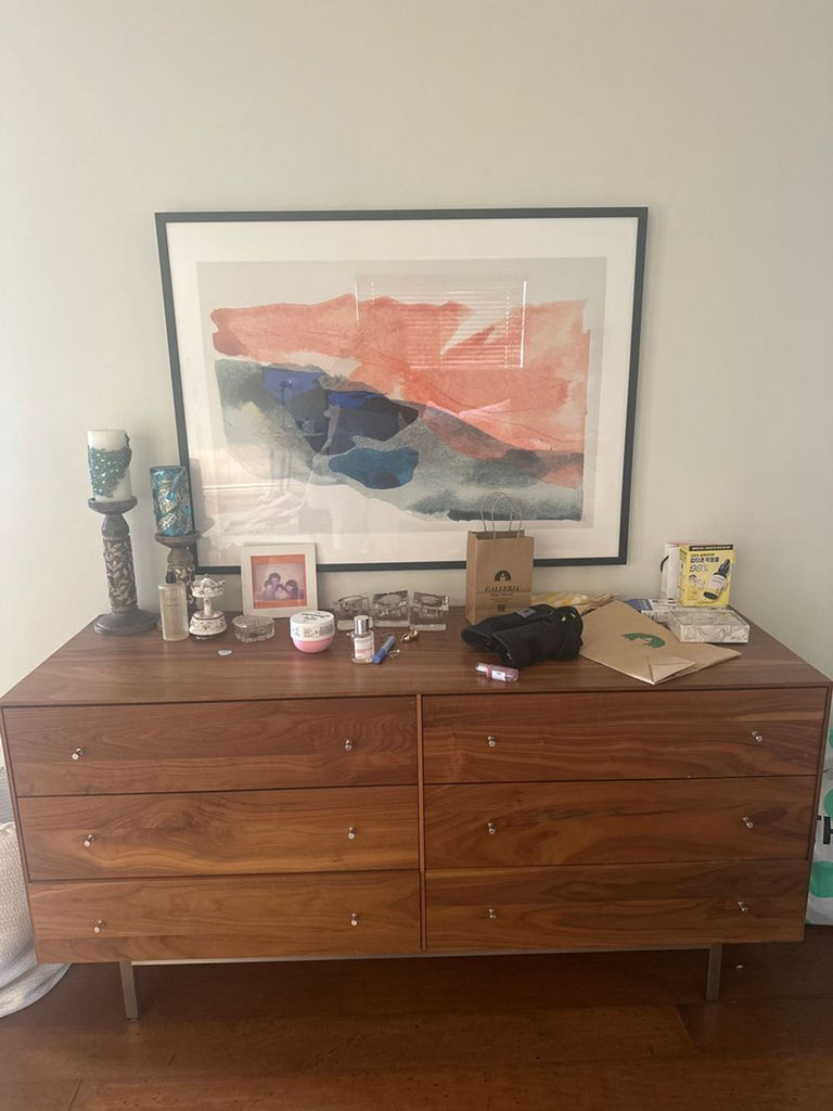 3. Walnut Room & Board dresser with six drawers, decorated with personal items and a framed art print above.
