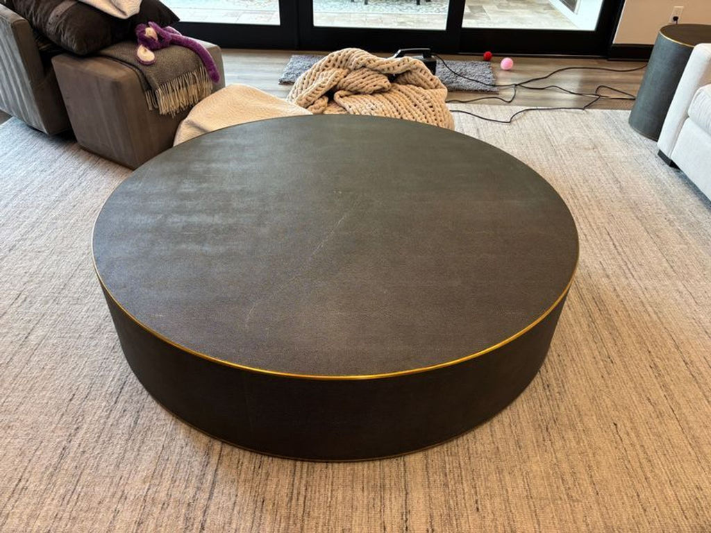 Modern round coffee table by Restoration Hardware; sturdy, spacious design with elegant brass trim.