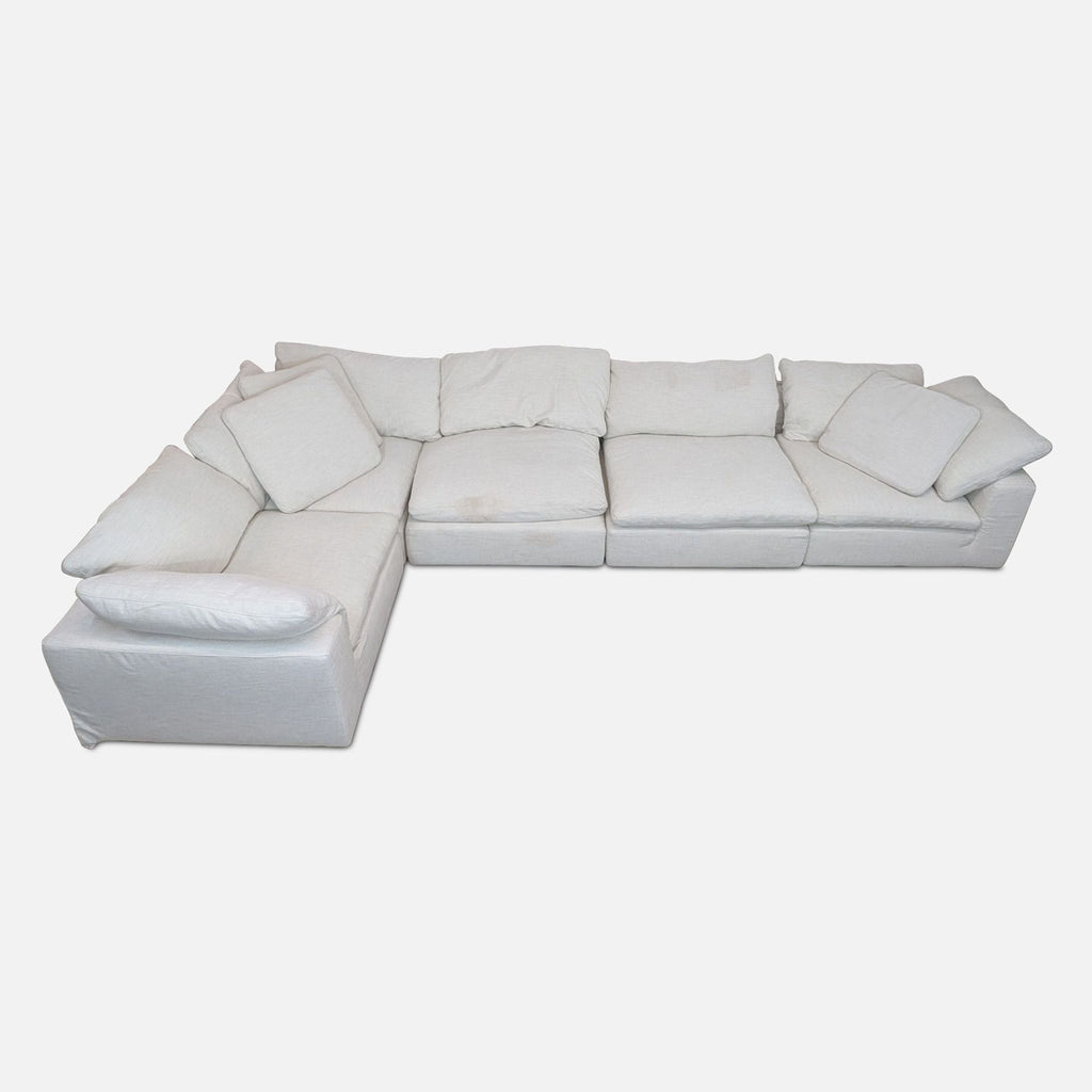 L-Shaped sectional sofa with removable plush cushions in light fabric.