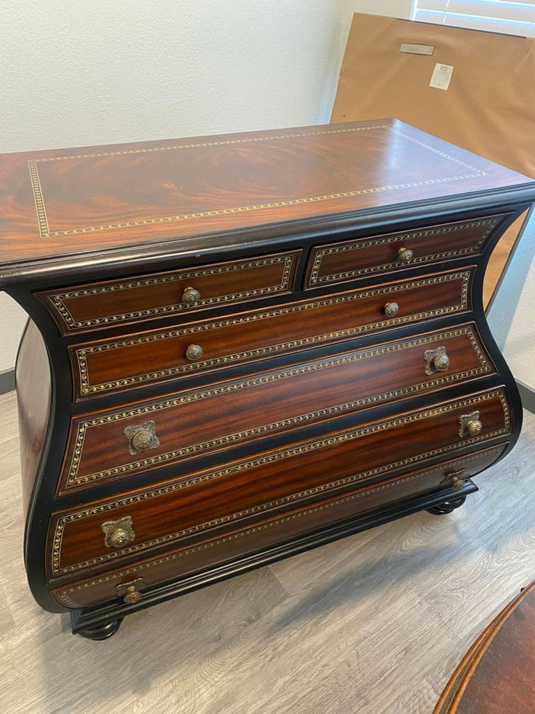 Elegant Thomasville dresser with sturdy design, curved edges, and ornate brass drawer pulls for a timeless look.
