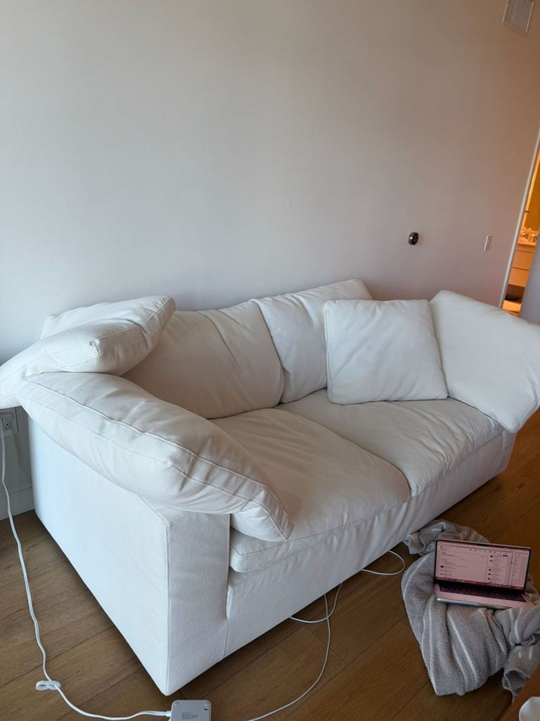 2. Modern white Restoration Hardware 3-seat sofa featuring deep seats and cozy cushions against a plain wall.