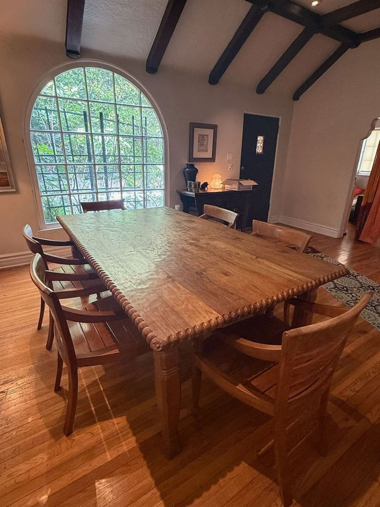 Solid wood dining set with rectangular table and five matching armchairs, one chair has a loose seat.