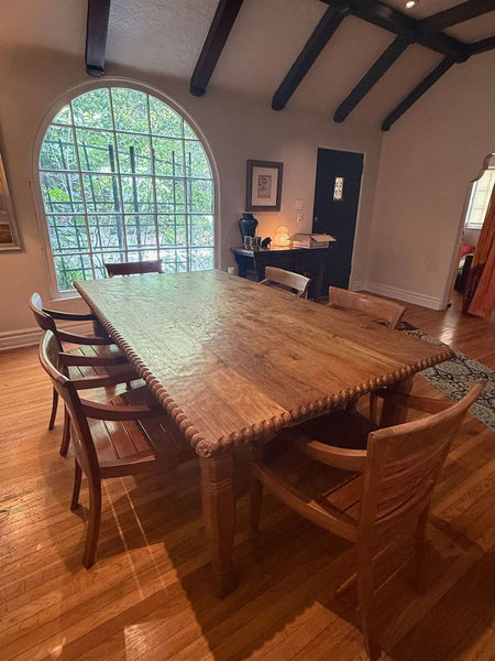 Solid wood dining set with rectangular table and five matching armchairs, one chair has a loose seat.