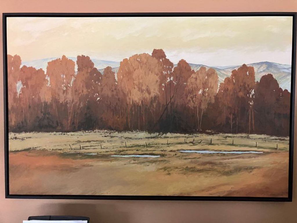 1. Framed landscape painting of autumn trees with distant hills, grassy field, and a few shallow water pools.