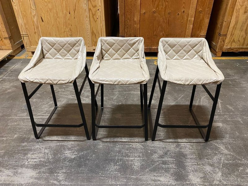 Set of two sleek Piet Boon Kekke counter stools with leather seats and metal frames, in neutral tones.  