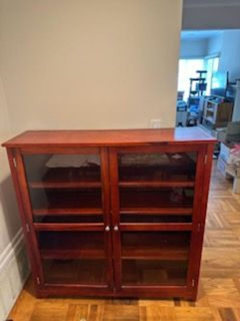 1. Elegant China cabinet with glass doors, showcasing shelves and intricate wood detailing for fine display.  