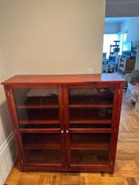 1. Elegant China cabinet with glass doors, showcasing shelves and intricate wood detailing for fine display.  